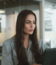 Attractive Brunette with Long Hair Typing on a Computer